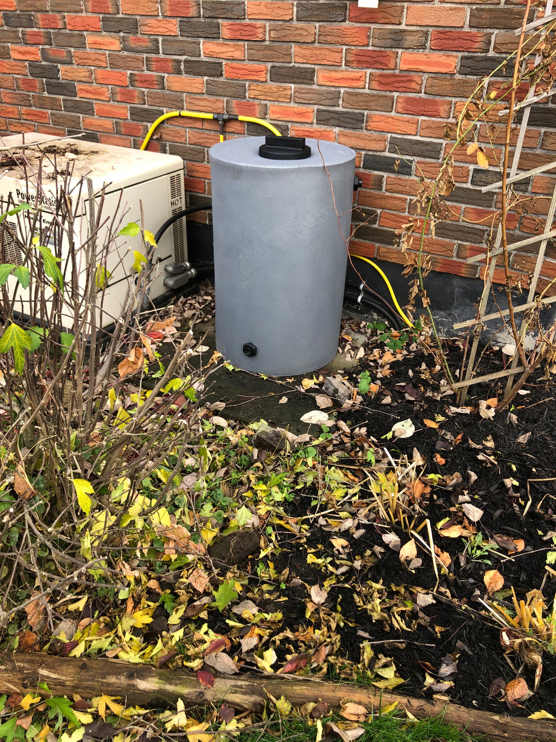 50gal rainwater tank on the side of a house.